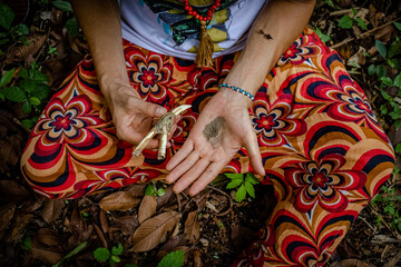 Sao Paulo, SP, Brazil - March 13 2022: Caucasian person hands in colorful clothes holding bone kuripe and snuff details. - obrazy, fototapety, plakaty