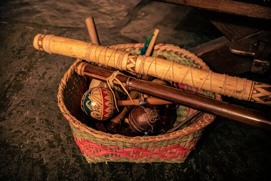 Sao Paulo, SP, Brazil - March 12 2022: Ethnic Guarani basket with Maracá indigenous instruments and flutes detail.