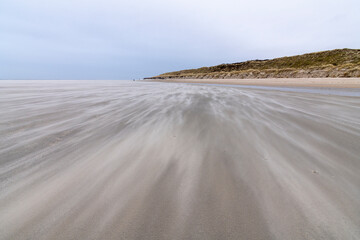 Sand fegt über den Strand bei Sturm