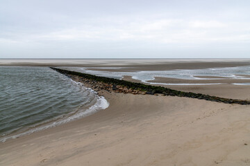 Sandstrand mit Wellen und Mole