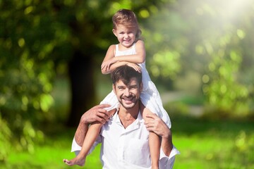 Happy dad carrying daughter on shoulders at park