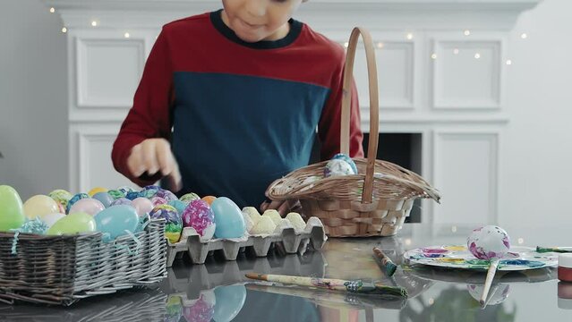 close up Young boy picking up Easter eggs and putting them into basket 4K