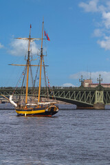 several old sailing ships parked on the Neva River in St. Petersburg against the blue sky and city