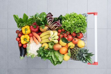 Shopping cart full of fresh vegetables and fruits