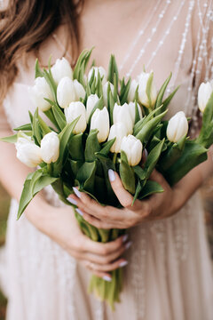 Big beautiful bouquet of white tulips in the hands of the bride