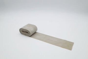 A rolled-up coil of rubber tourniquet to stop the blood. Elastic beige ribbon for sports, fitness and stretching.