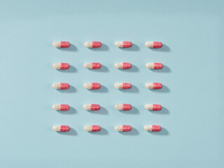 Pills in a row on blue background. Horizontal composition.