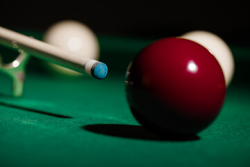 Man playing billiard sport game, red and white balls, cue and green pool table background