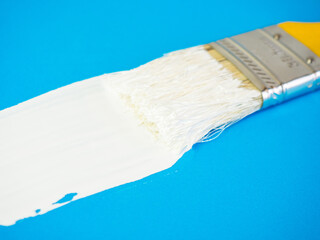 brush with white paint draws space for text on blue background