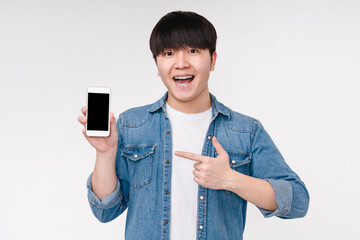 Young korean asian man boy freelancer student pointing at smart phone cellphone blank screen with mockup copy space, showing advert, using online application isolated on white background - Powered by Adobe