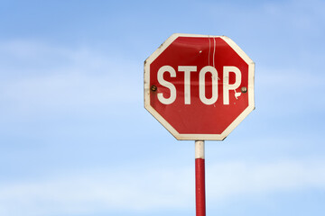stop sign in front of blue sky