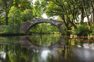 An old packhorse bridge over a body of water at Stainforth in the Yorkshire Dales, UK