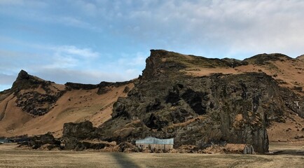 In schwarzen Fels gebaute Scheune der Drangshlid Farm im Süden von Island