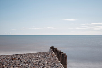 A rocky beach coastline with timber groynes going into ocean at Hornsea East Yorkshire