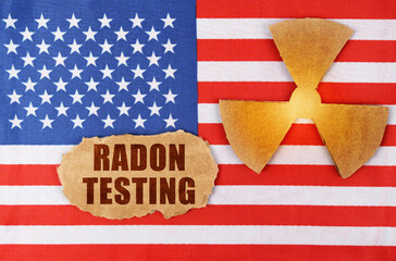Fototapeta na wymiar On the US flag, the symbol of radioactivity and torn cardboard with the inscription - Radon Testing