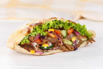 Döner Kebab Doner Kebap slice fast food in flatbread on a wooden board