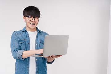 Happy asian korean young coder programmer student man freelancer hacker working remotely on laptop,...