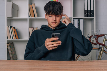 pensive teenager looking at mobile phone