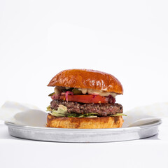 burger with fries and vegetables on white background