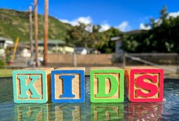 wooden cube toys for kids. Kids on it. he is writing. Background with nature view © buraktumler