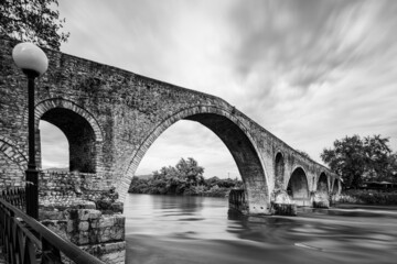 Stone arch bridge over river in Arta city, Greece.