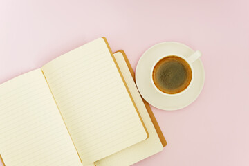 Top view mock-up close-up of two notebooks for writing and a white porcelain cup with coffee on a pink background. Selective focus.