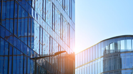 Perspective view to steel and  blue glass. Commercial modern city of future. Business concept of successful industrial architecture. The sunlight falling on the building.