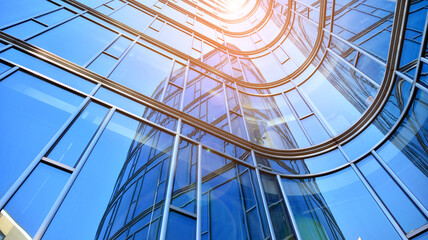 Perspective view to steel and  blue glass. Commercial modern city of future. Business concept of successful industrial architecture. The sunlight falling on the building.
