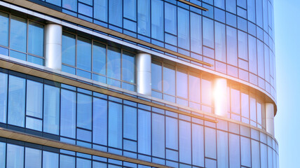 Fototapeta na wymiar Perspective view to steel and blue glass. Commercial modern city of future. Business concept of successful industrial architecture. The sunlight falling on the building.