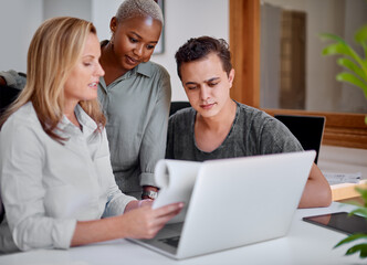 Obraz premium They never lack passion and dedication for work. Shot of a group of businesspeople working together on a laptop in an office.