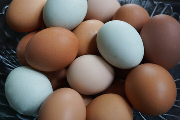 Fresh brown and white eggs in glass bowl. Multicolour eggs. Natural healthy organic food, cooking concept
