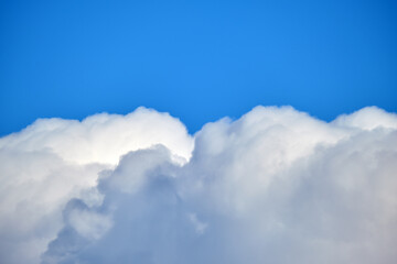 Bright landscape of white puffy cumulus clouds on blue clear sky