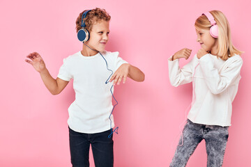 boy and girl listening to music pink color background