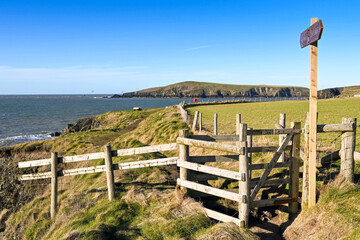 Wooden gate and signpost on the Wales National Coastal Path at Gwbert on Sea near Cardigan in west...