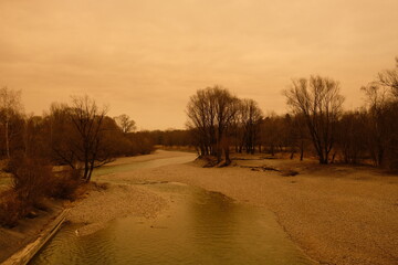 Saharastaub macht gelben Himmel an der Isar am 15.3.2022 im Münchner Süden
