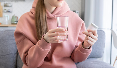 Close-up woman holding pills time to take medications, cure for headache, high blood pressure or cholesterol level remedy pain killer drugs.