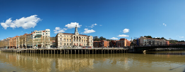 Fototapeta na wymiar Panoramic view of the river in the city of Bilbao on a day with a blue sky and some white clouds.