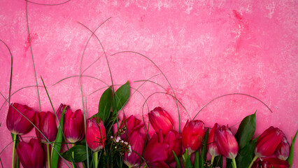 Row of red tulips on wooden background with space for message. Mother's Day background. Top view