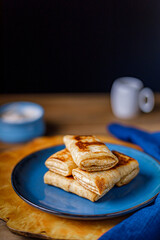 Pancakes with curd filling on a blue plate.