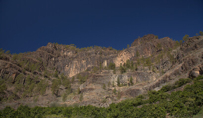 Fototapeta na wymiar Gran Canaria, landscape of the southern part of the island along Barranco de Arguineguín steep and deep ravine with vertical rock walls, circular hiking route starting at a hamlet Barranquillo Andres 