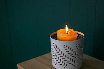 Beeswax candle on dark green background