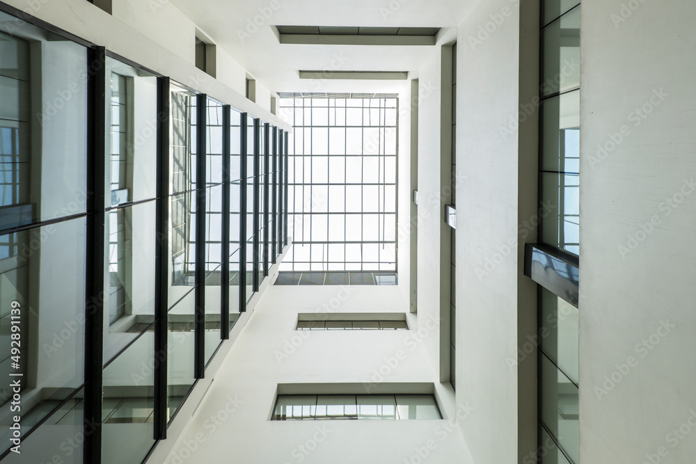 Wall mural low angle shot of an atrium of an office building with a glass roof