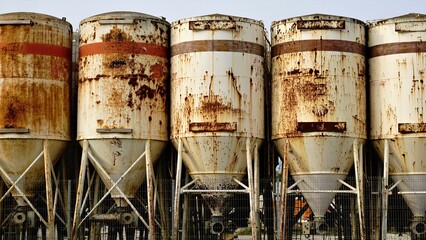 group of oxidized cement mixing silos