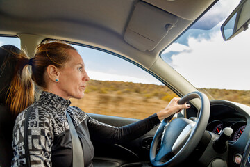 Woman seen from the side driving a car at high speed