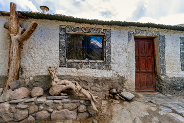 Facade of an adobe house with decorations in a town in Salta, Argentina