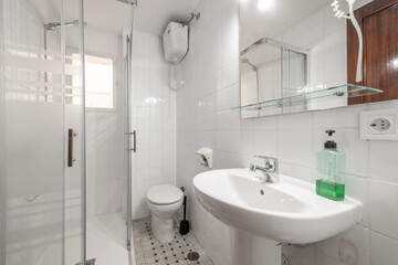 Fototapeta na wymiar Bathroom with white porcelain sink with mirror and glass shelf and shower cubicle to one side