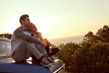 Feels good to breakaway from the city. Shot of an affectionate young couple on a roadtrip. - obrazy, fototapety, plakaty