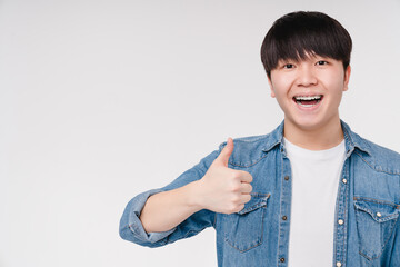 Happy young asian korean boy man student showing thumb up, saying yes, agrees, smiling with braces...