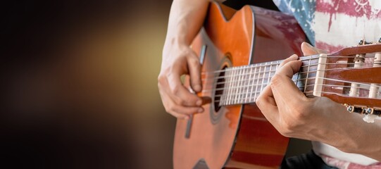 Guitarist male hands playing the guitar. Classical concert, performance, show.