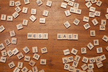 west and east letters on wooden background
